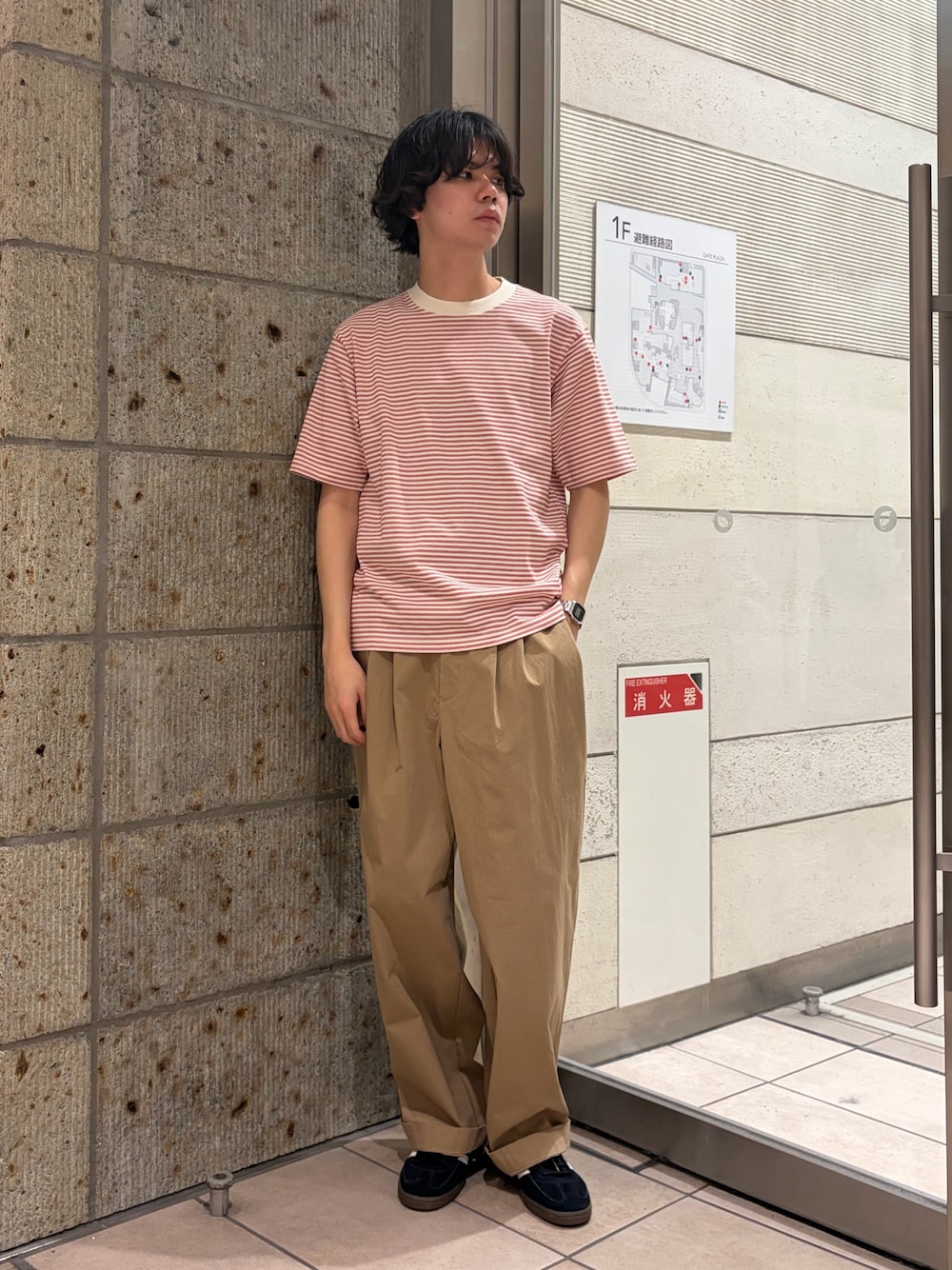 レッド系のTシャツ/カットソー、ベージュ系のその他パンツ、ブラック系のスニーカーを着用したメンズの春コーディネートの1枚目の写真