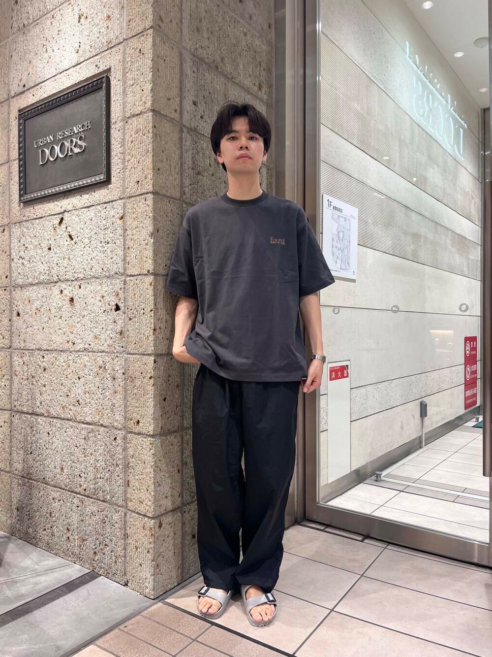 グレー系のサンダル、ブラック系のその他パンツ、グレー系のTシャツ/カットソーを着用したメンズの夏コーディネートの1枚目の写真