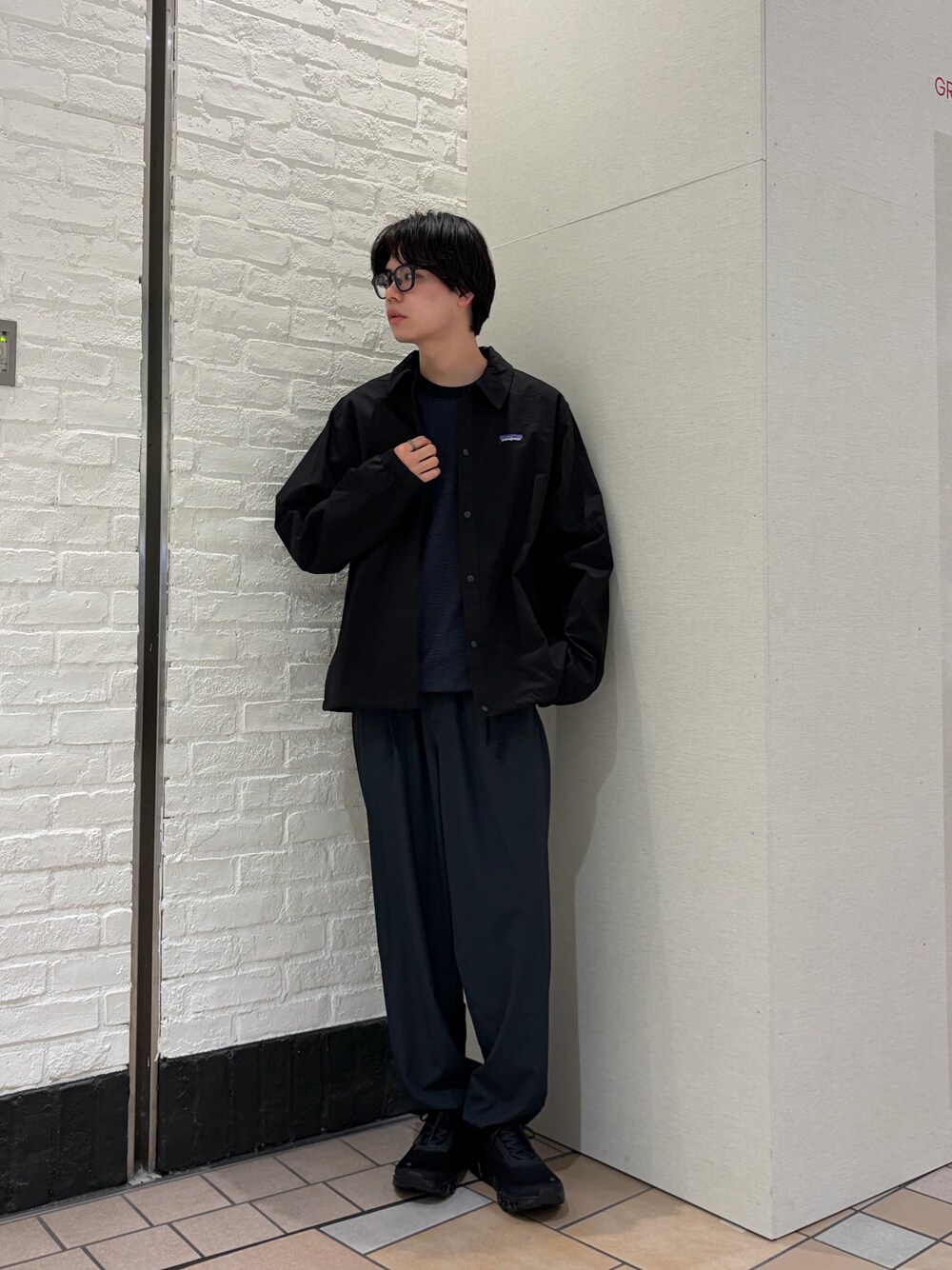 ブラック系のカバーオール、ブルー系のTシャツ/カットソー、ブラック系のスニーカーを着用したメンズの春コーディネートの1枚目の写真