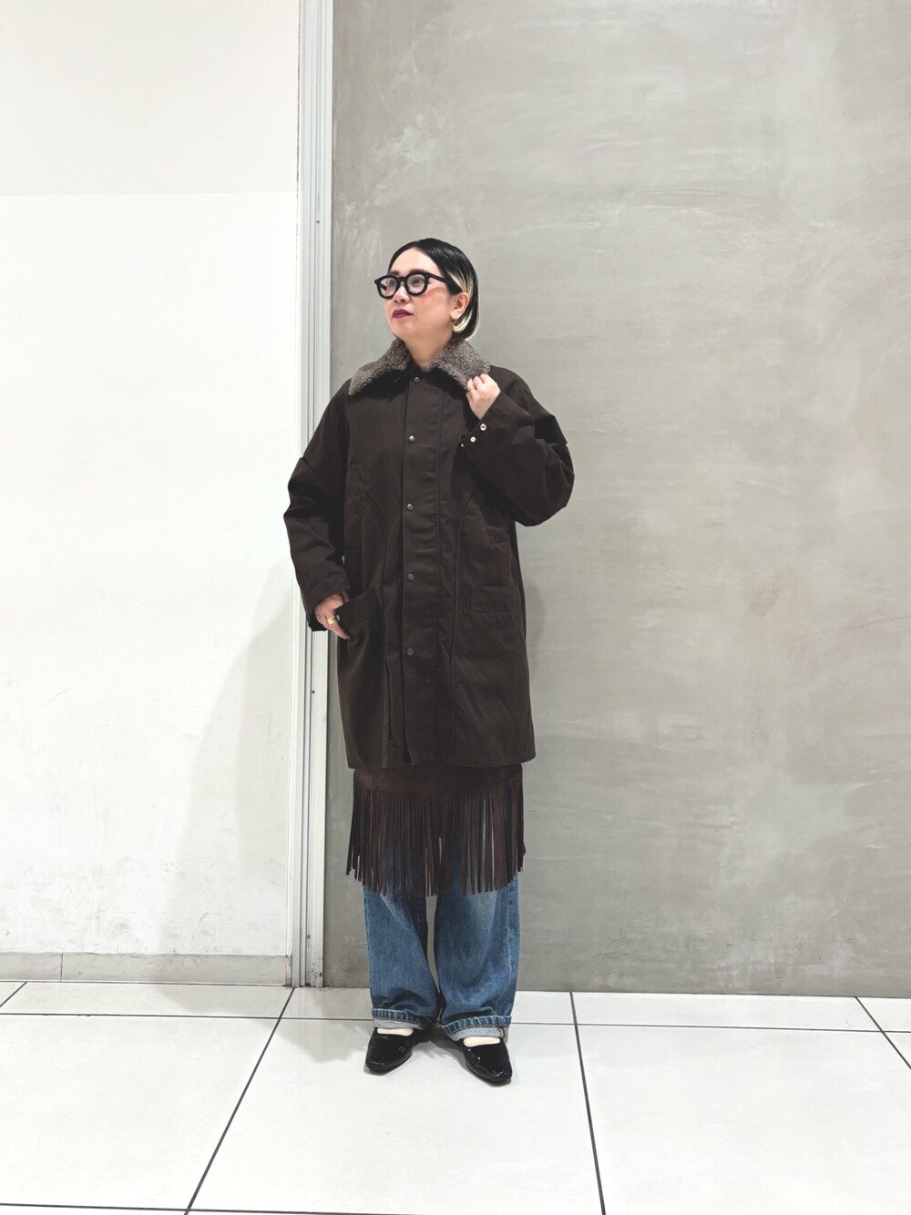 ブラウン系のその他アウター、ホワイト系のTシャツ/カットソー、ブラウン系のスカートを着用したレディースの秋コーディネートの1枚目の写真