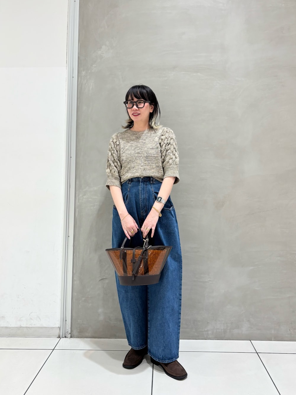 ホワイト系のニット/セーター、ブルー系のデニムパンツ、ブラウン系のローファーを着用したレディースの春コーディネートの1枚目の写真