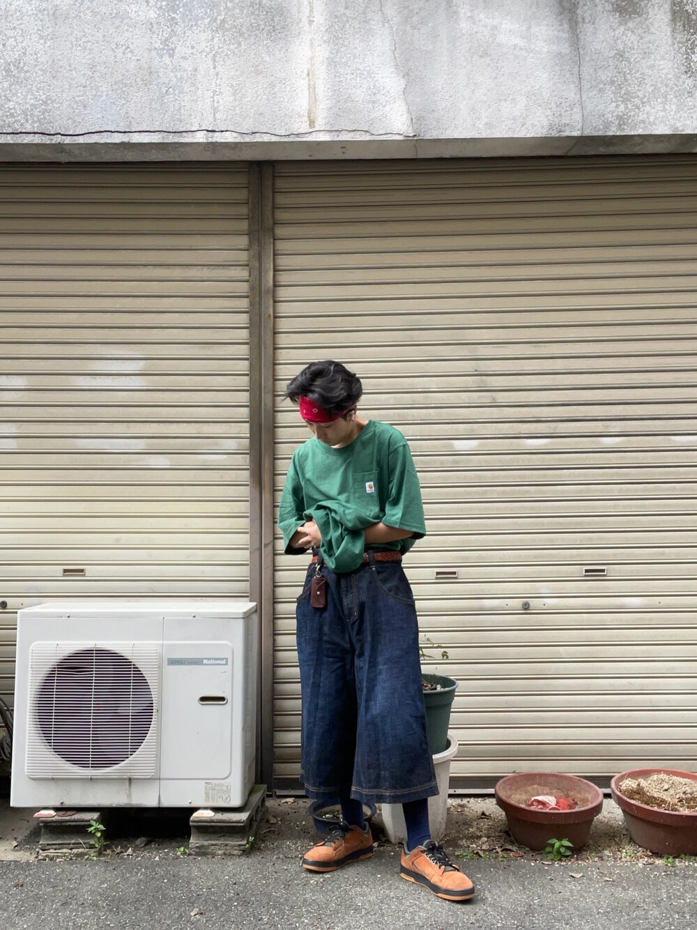 グリーン系のTシャツ/カットソー、ブルー系のデニムパンツ、ブラウン系のスニーカーを着用したメンズの秋コーディネートの1枚目の写真