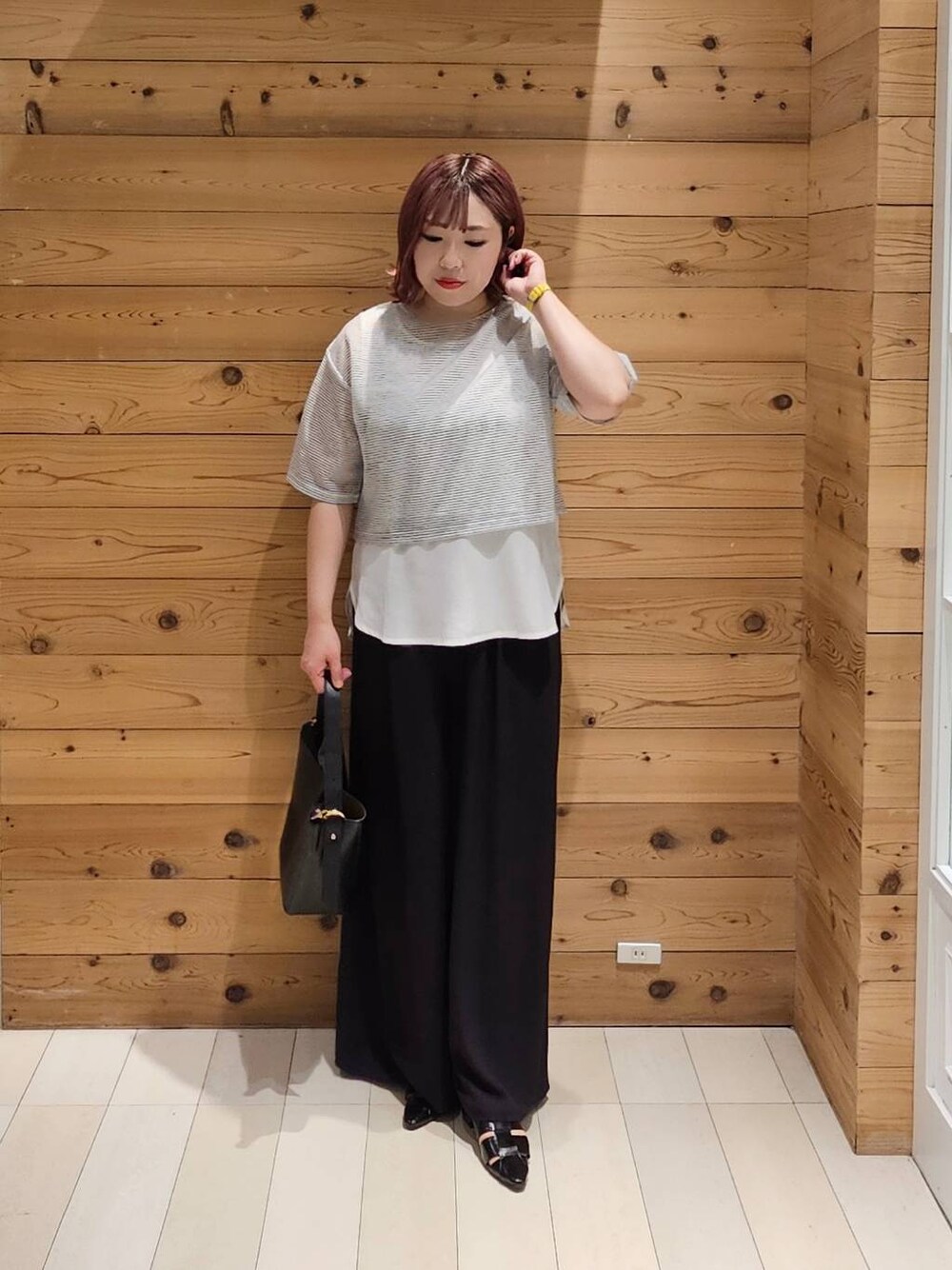 ブラック系のショルダーバッグ、ホワイト系のTシャツ/カットソー、ブラック系のパンプスを着用したレディースの夏コーディネートの1枚目の写真