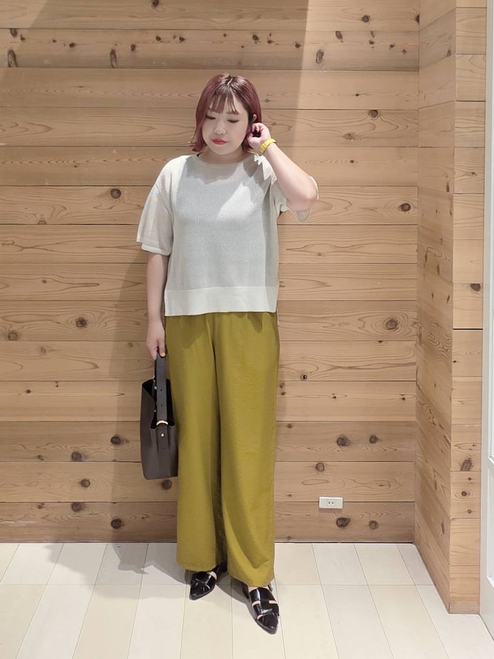 ブラウン系のショルダーバッグ、ブラック系のタンクトップ、ブラック系のパンプスを着用したレディースの夏コーディネートの1枚目の写真