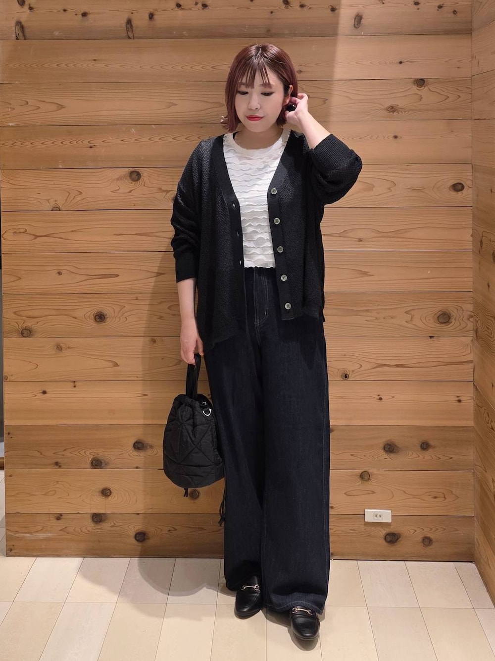 ブラック系のローファー、ブルー系のデニムパンツ、ブラック系のハンドバッグを着用したレディースの秋コーディネートの1枚目の写真