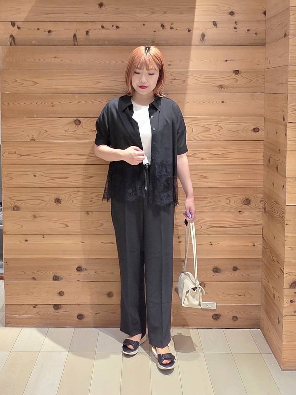 ベージュ系のショルダーバッグ、ブラック系のその他パンツ、ブラック系のサンダルを着用したレディースの夏コーディネートの1枚目の写真