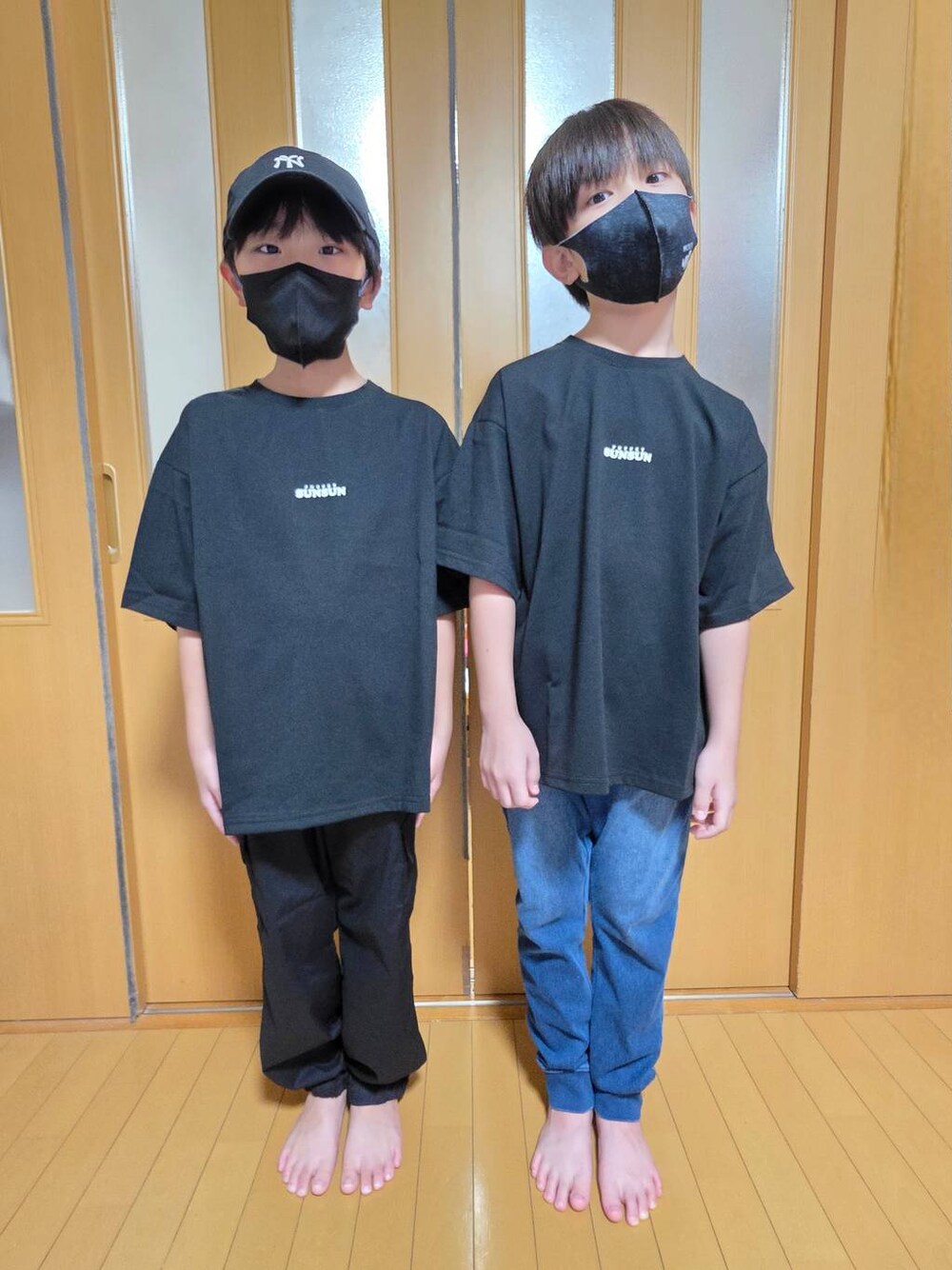 ブルー系のデニムパンツ、ブラック系のカーゴパンツ、ブラック系のキャップを着用したキッズの秋コーディネートの1枚目の写真