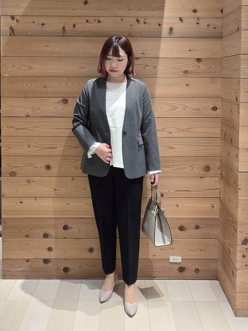 ホワイト系のショルダーバッグ、ホワイト系のパンプス、ブルー系のセットアップを着用したレディースの冬コーディネートの1枚目の写真