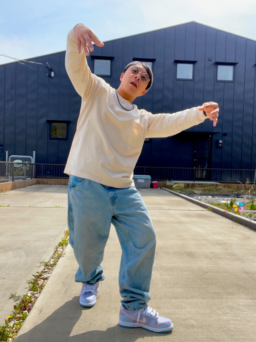 ブルー系のデニムパンツ、ベージュ系のTシャツ/カットソー、ブルー系のスニーカーを着用したメンズの春コーディネートの1枚目の写真