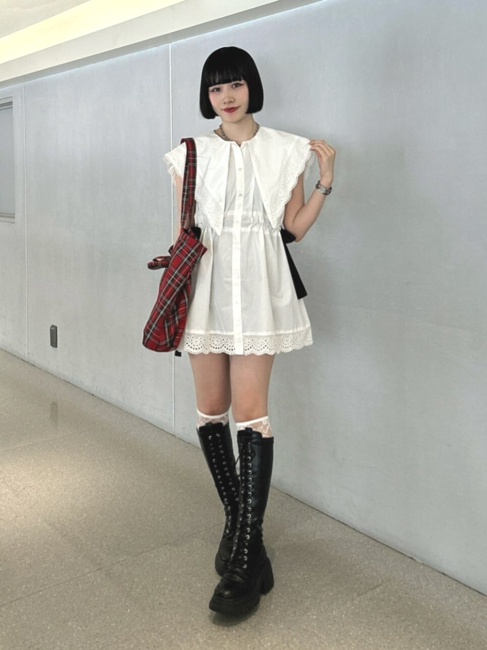 ブラック系のブーツ、ホワイト系のシャツ/ブラウス、レッド系のトートバッグを着用したレディースの夏コーディネートの1枚目の写真