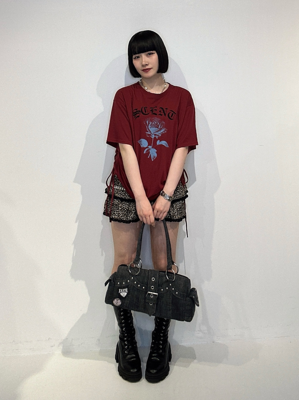 レッド系のTシャツ/カットソー、ブラウン系のスカート、ブラック系のブーツを着用したレディースの夏コーディネートの1枚目の写真
