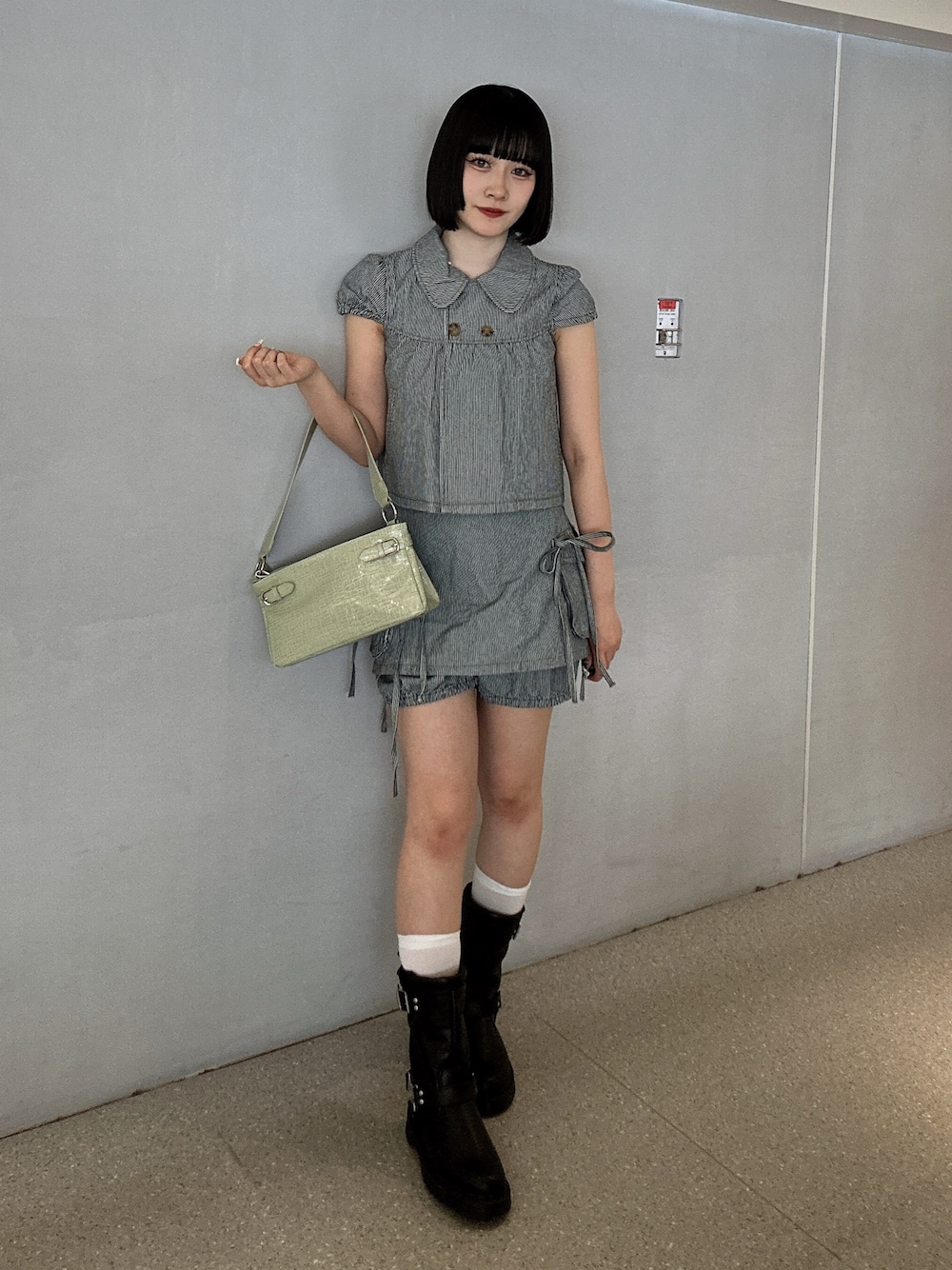 ブラック系のその他トップス、ブラック系のデニムパンツ、グリーン系のハンドバッグを着用したレディースの春コーディネートの1枚目の写真