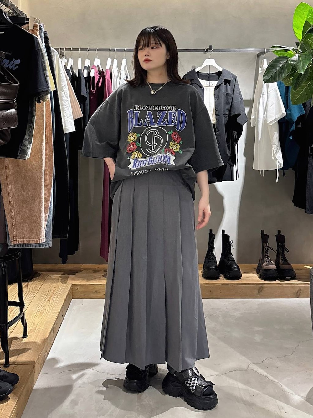 ブラック系のサンダル、グレー系のスカート、シルバー系のネックレスを着用したレディースの春コーディネートの1枚目の写真