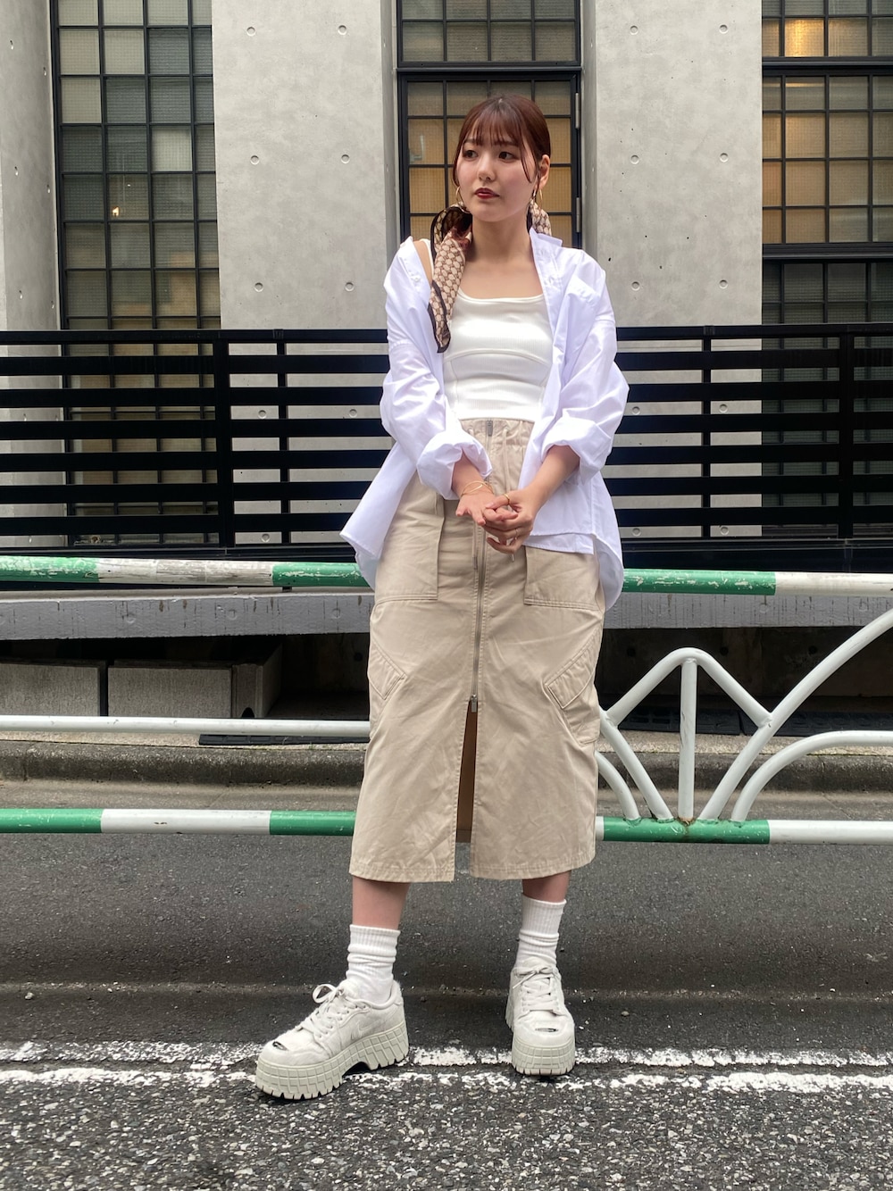 ベージュ系のスカートを着用したレディースの夏コーディネートの1枚目の写真