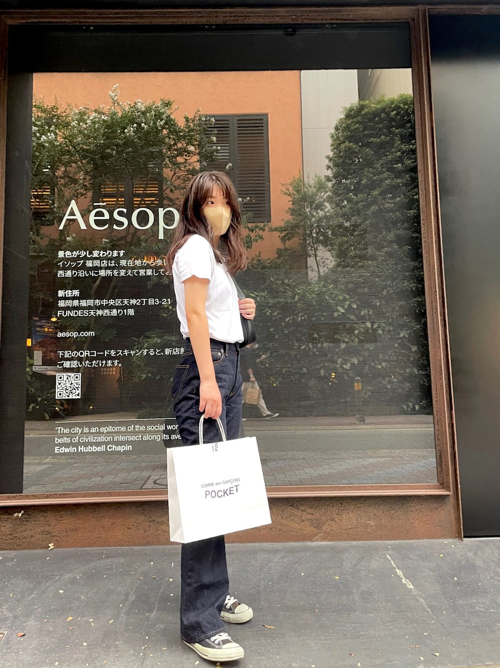 ブルー系のデニムパンツ、ブラック系のスニーカー、ブラウン系のアナログ腕時計を着用したレディースの夏コーディネートの1枚目の写真