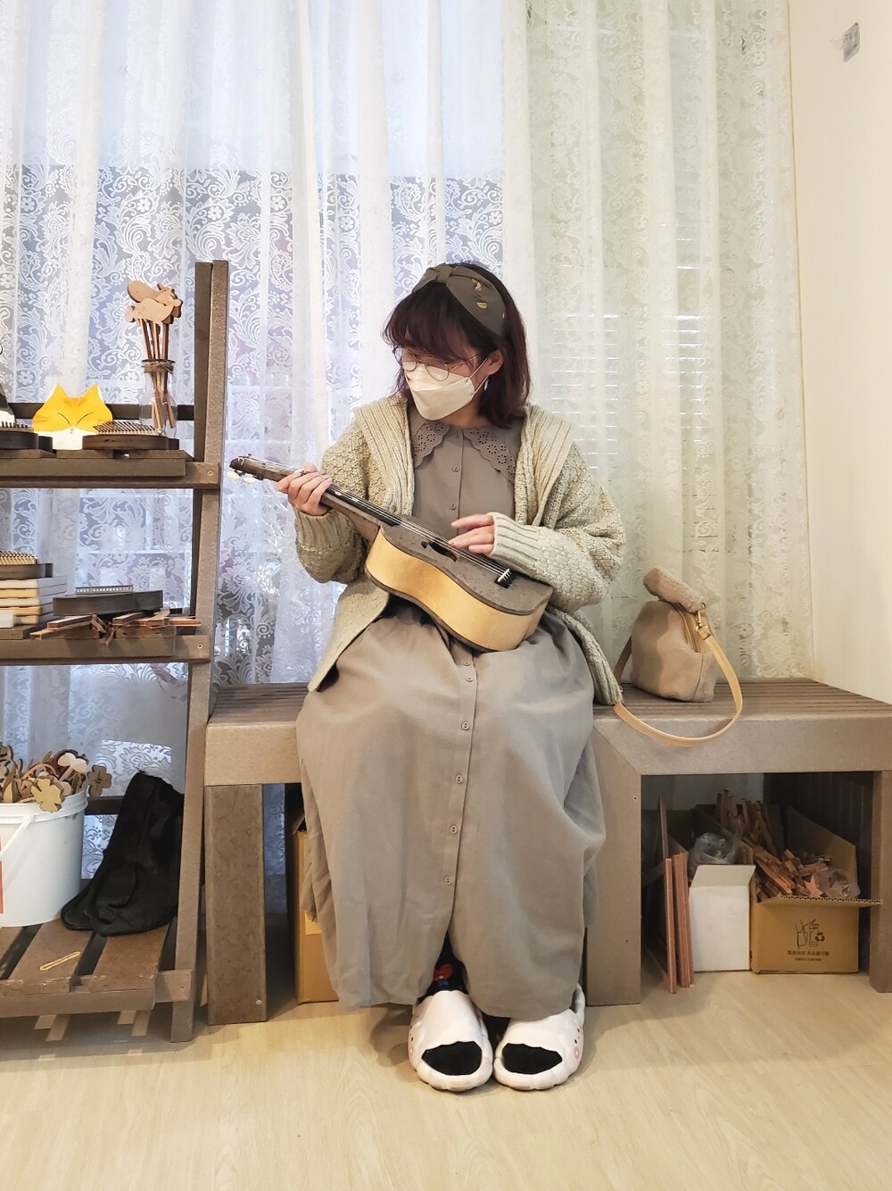 グリーン系のワンピース、ベージュ系のニット/セーター、ブラウン系のブーツを着用したレディースの冬コーディネートの1枚目の写真