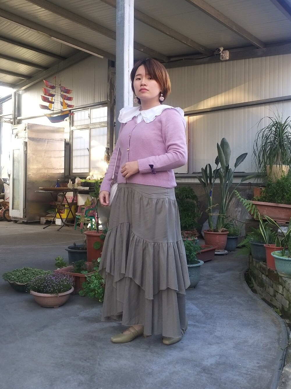 パープル系のカーディガン/ボレロ、ホワイト系のシャツ/ブラウス、グリーン系のスカートを着用したレディースの春コーディネートの3枚目の写真