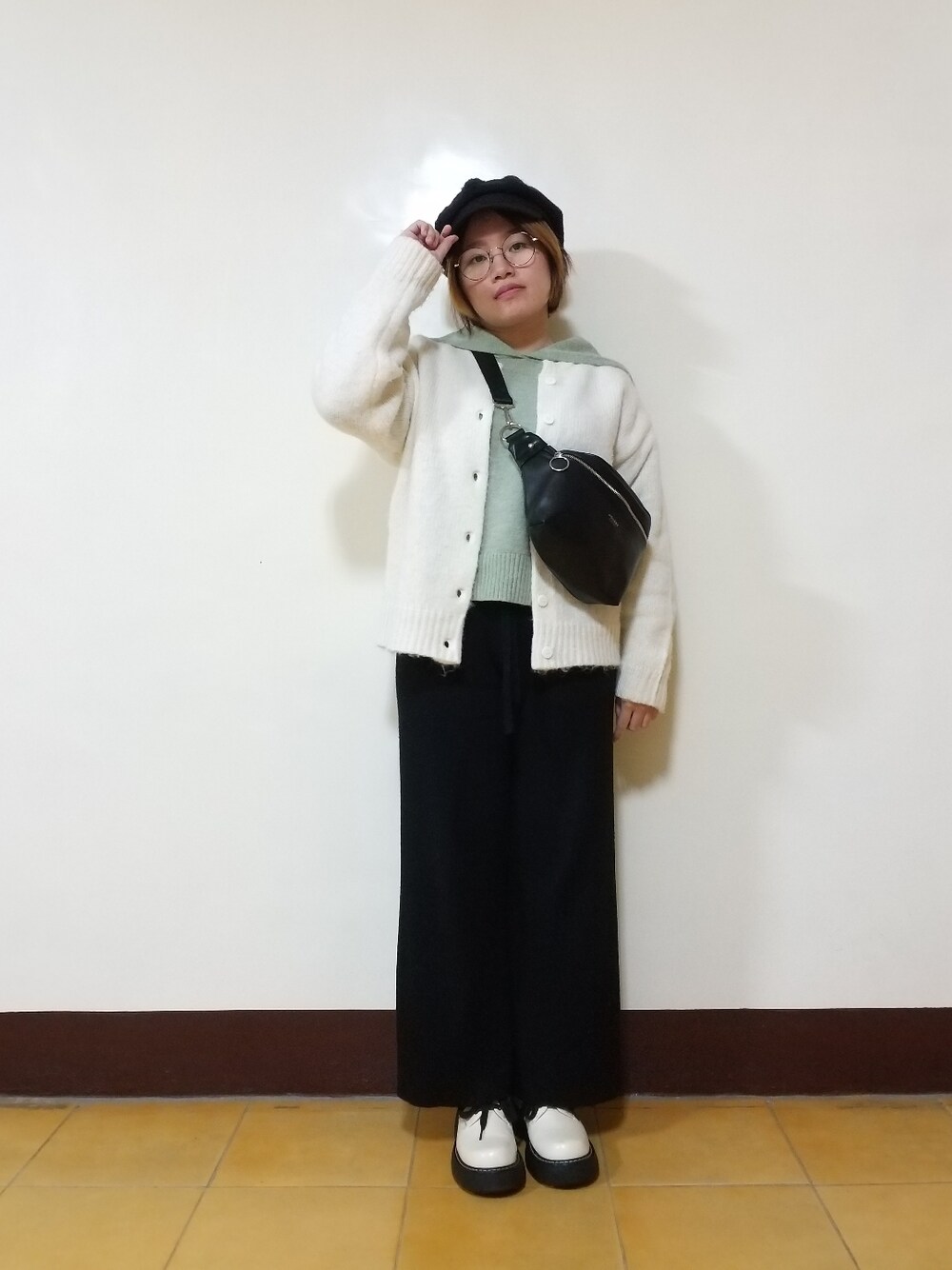 グリーン系のニット/セーター、ホワイト系のカーディガン/ボレロ、ブラック系のパンツを着用したレディースの冬コーディネートの2枚目の写真