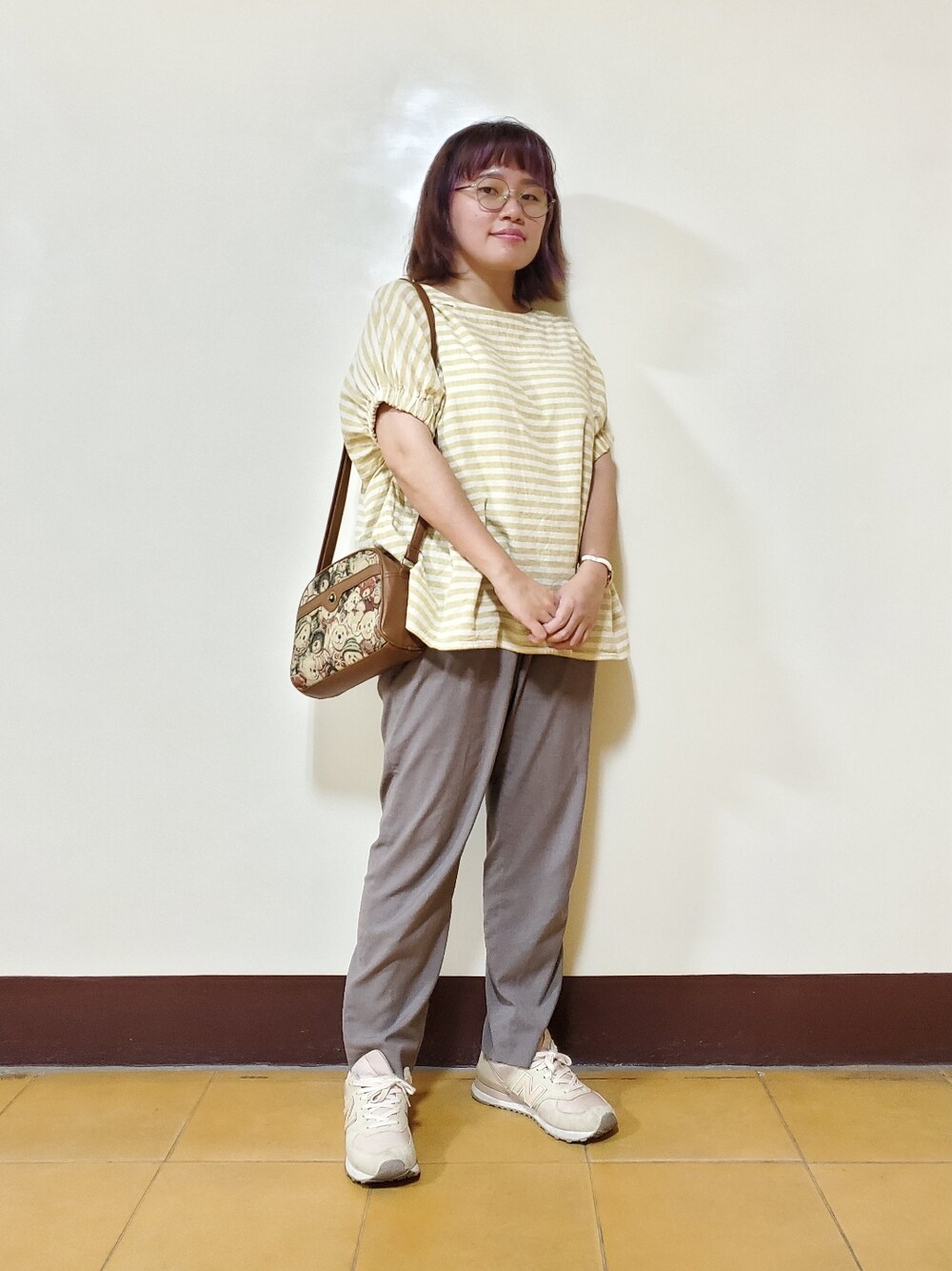 イエロー系のシャツ/ブラウス、グレー系のスラックス、ベージュ系のシューズを着用したレディースの秋コーディネートの1枚目の写真