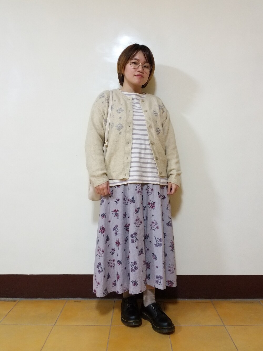 パープル系のTシャツ/カットソー、ベージュ系のカーディガン/ボレロ、グレー系のスカートを着用したレディースの春コーディネートの2枚目の写真