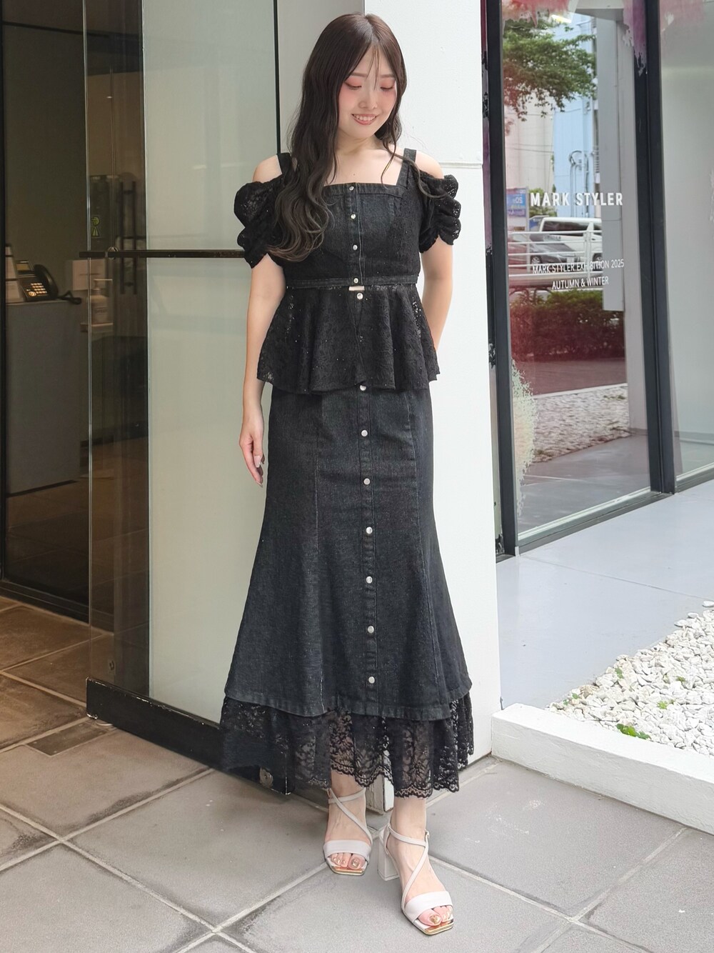 ブラック系のシャツ/ブラウス、ブラック系のスカート、ベージュ系のサンダルを着用したレディースの夏コーディネートの1枚目の写真