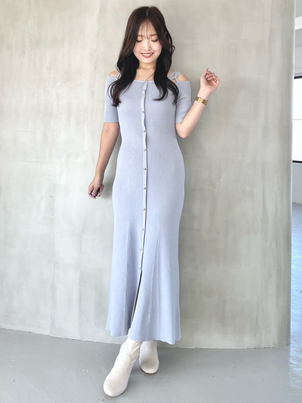 ブルー系のワンピース、ホワイト系のブーツを着用したレディースの秋コーディネートの1枚目の写真