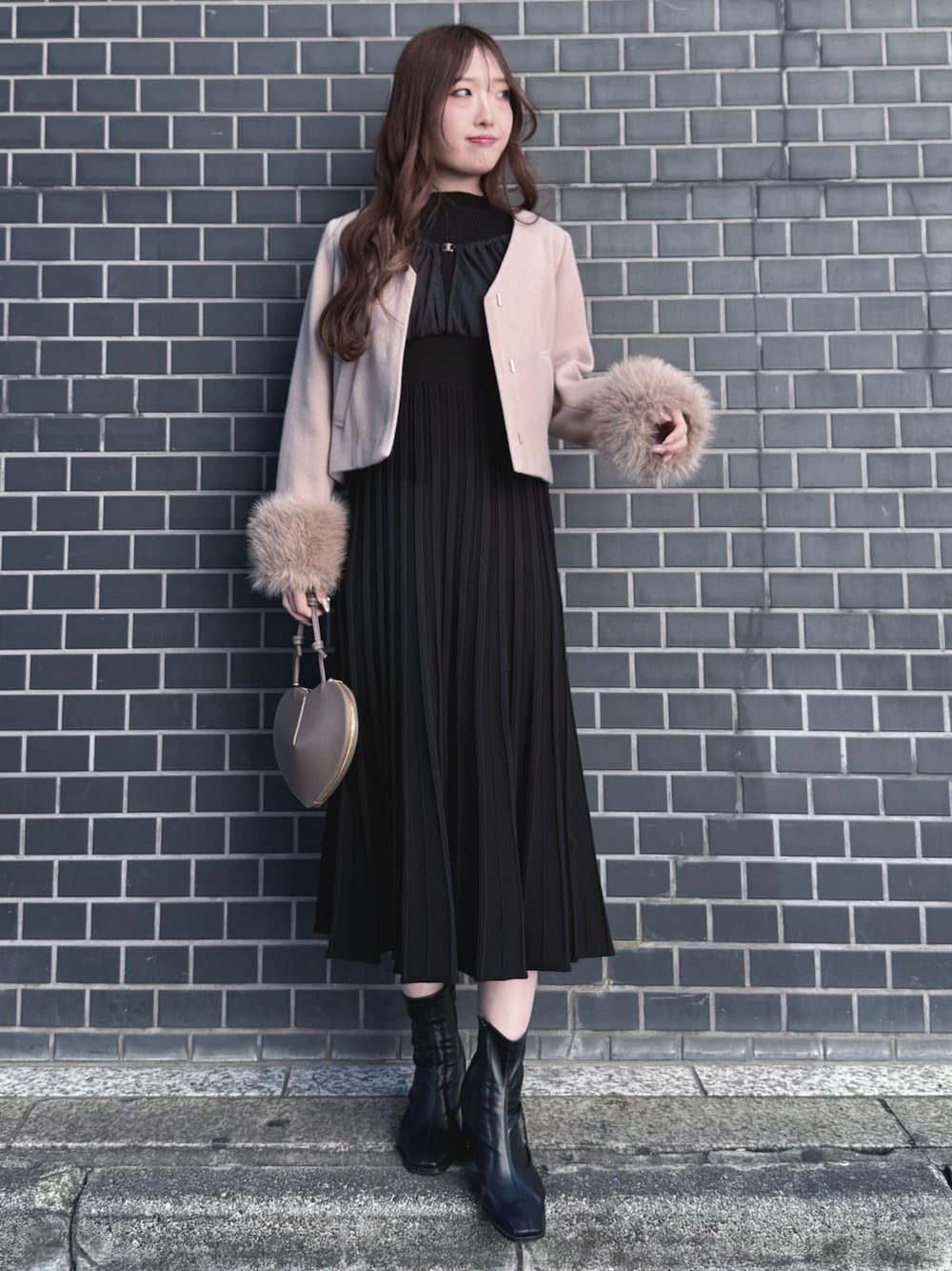 ブラック系のブーツ、ブラック系のワンピース、ベージュ系のショルダーバッグを着用したレディースの冬コーディネートの1枚目の写真