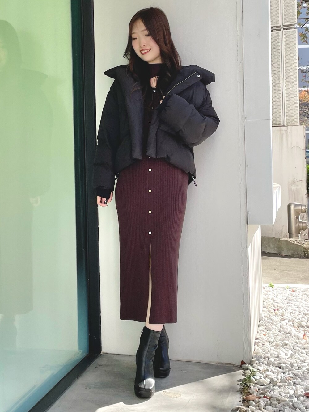 ブラック系のダウンジャケット/コート、ブラウン系のワンピース、ブラック系のブーツを着用したレディースの冬コーディネートの1枚目の写真