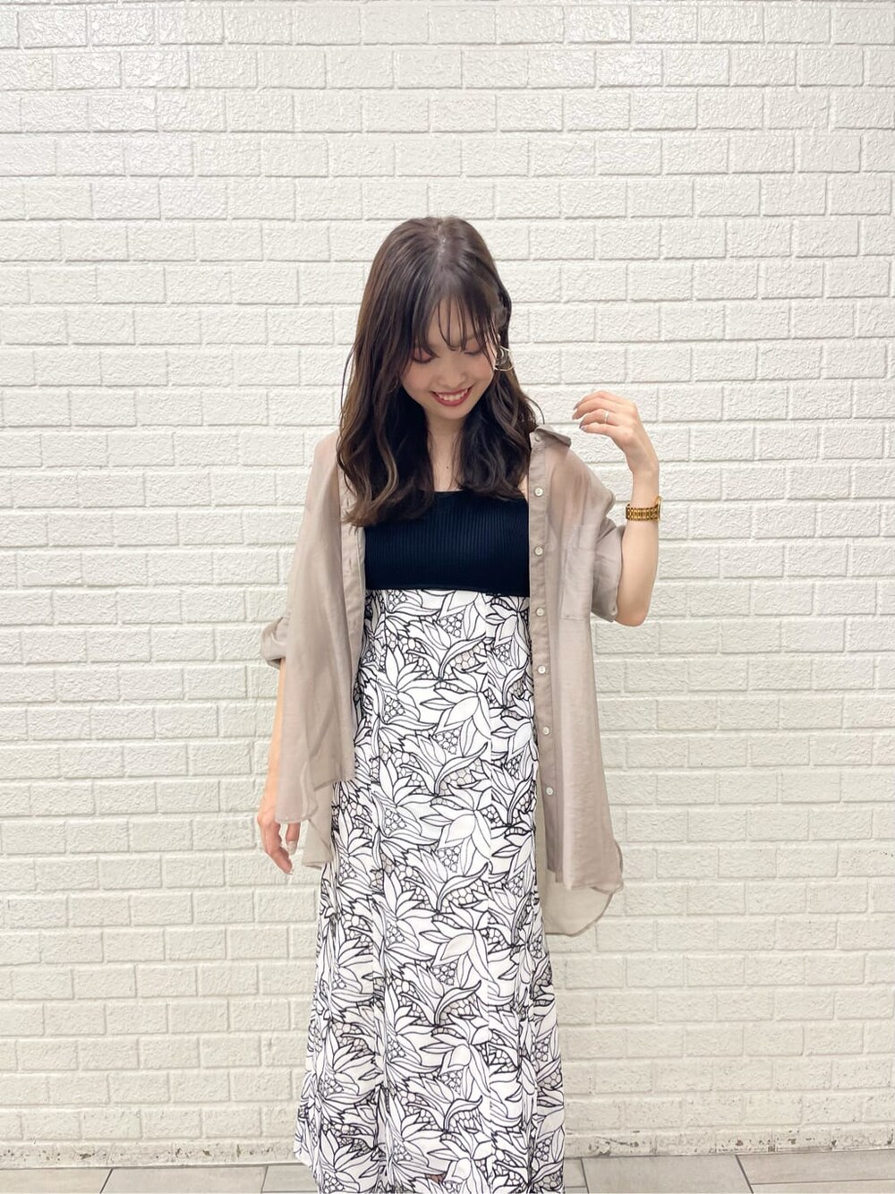 ベージュ系のサンダル、ブラック系のワンピース、ベージュ系のシャツ/ブラウスを着用したレディースの夏コーディネートの1枚目の写真