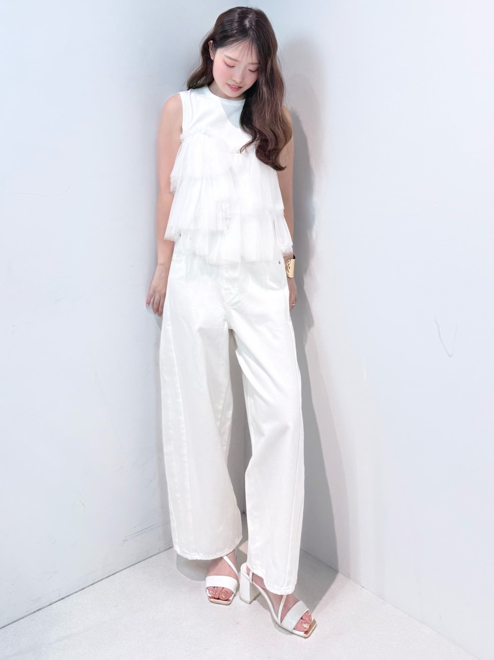 ホワイト系のデニムパンツ、ホワイト系のサンダル、ホワイト系のTシャツ/カットソーを着用したレディースの春コーディネートの1枚目の写真