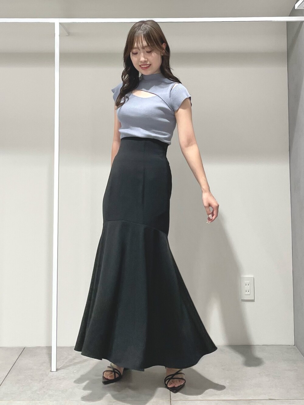 ブルー系のニット/セーター、ブラック系のスカート、ブラック系のサンダルを着用したレディースの夏コーディネートの1枚目の写真