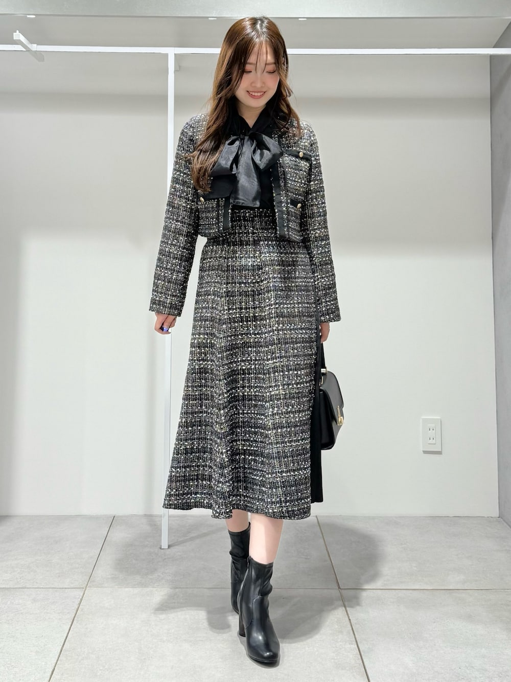 ブラック系のテーラードジャケット、ブラック系のスカート、ブラック系のシャツ/ブラウスを着用したレディースの秋コーディネートの1枚目の写真