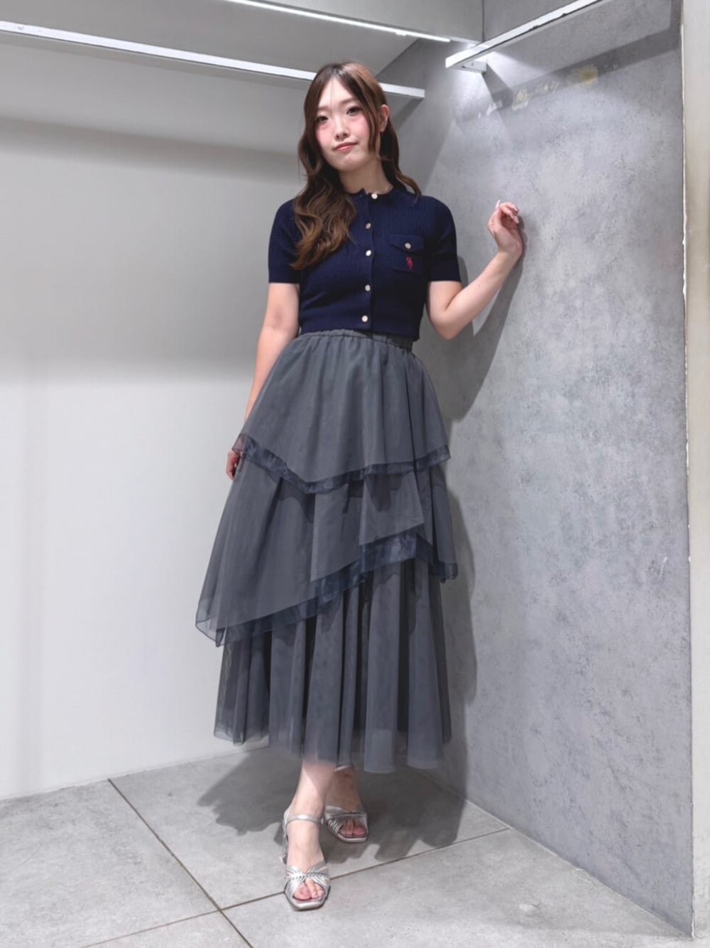 シルバー系のサンダル、ブルー系のカーディガン/ボレロ、グレー系のスカートを着用したレディースの夏コーディネートの1枚目の写真