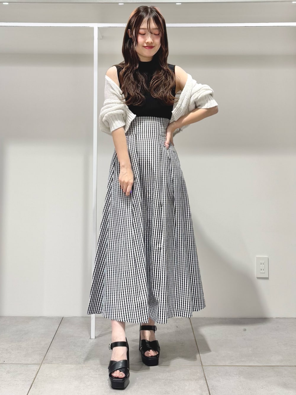 ブラック系のサンダル、その他のスカート、ブラック系のニット/セーターを着用したレディースの春コーディネートの1枚目の写真