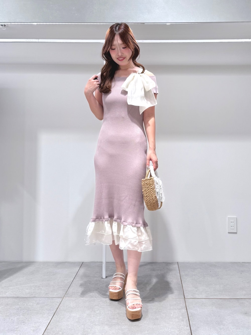 ベージュ系のハンドバッグ、その他のサンダル、ピンク系のワンピースを着用したレディースの夏コーディネートの1枚目の写真