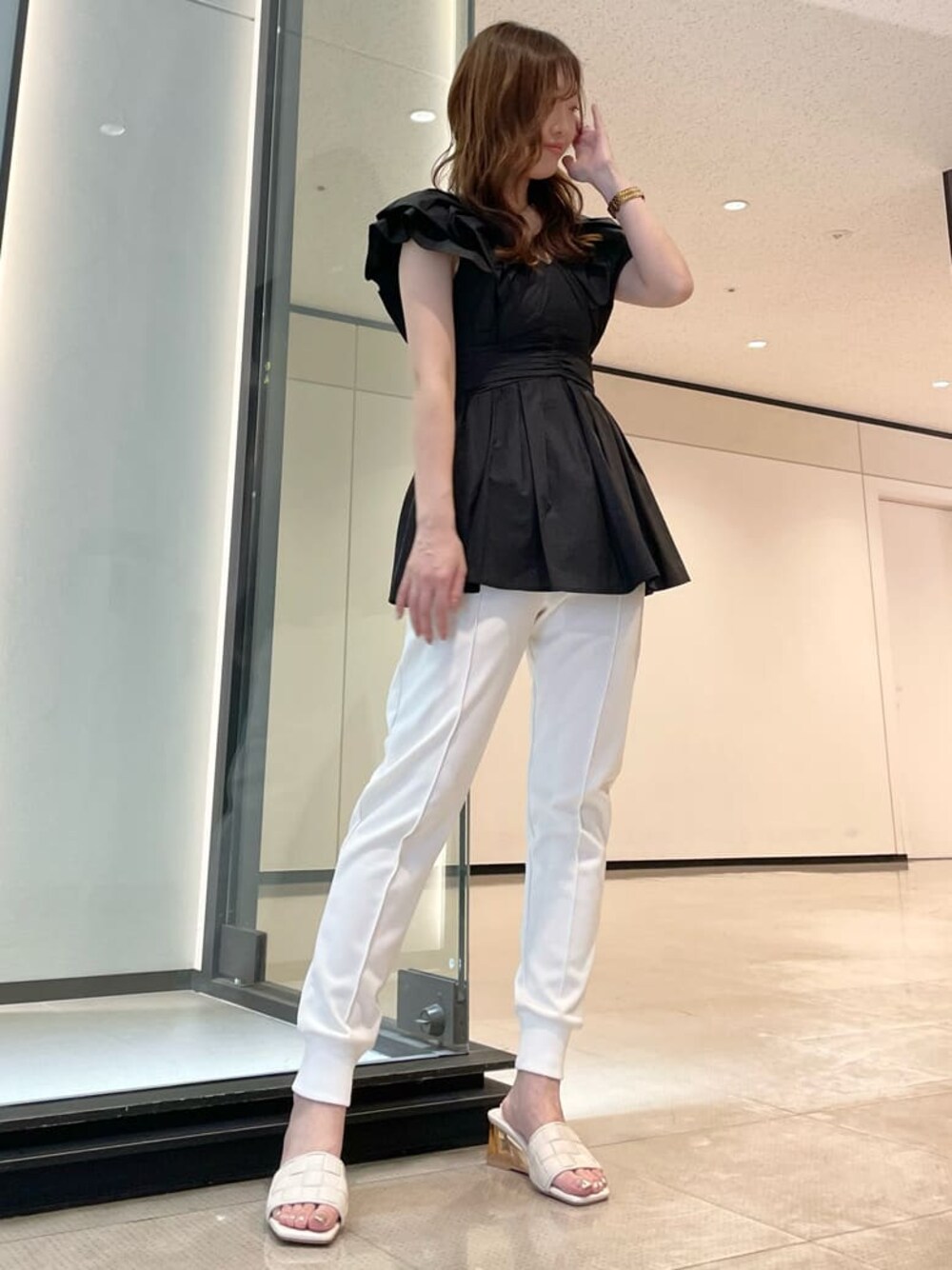 ブラック系のシャツ/ブラウス、ホワイト系のサンダル、ホワイト系のその他パンツを着用したレディースの春コーディネートの1枚目の写真