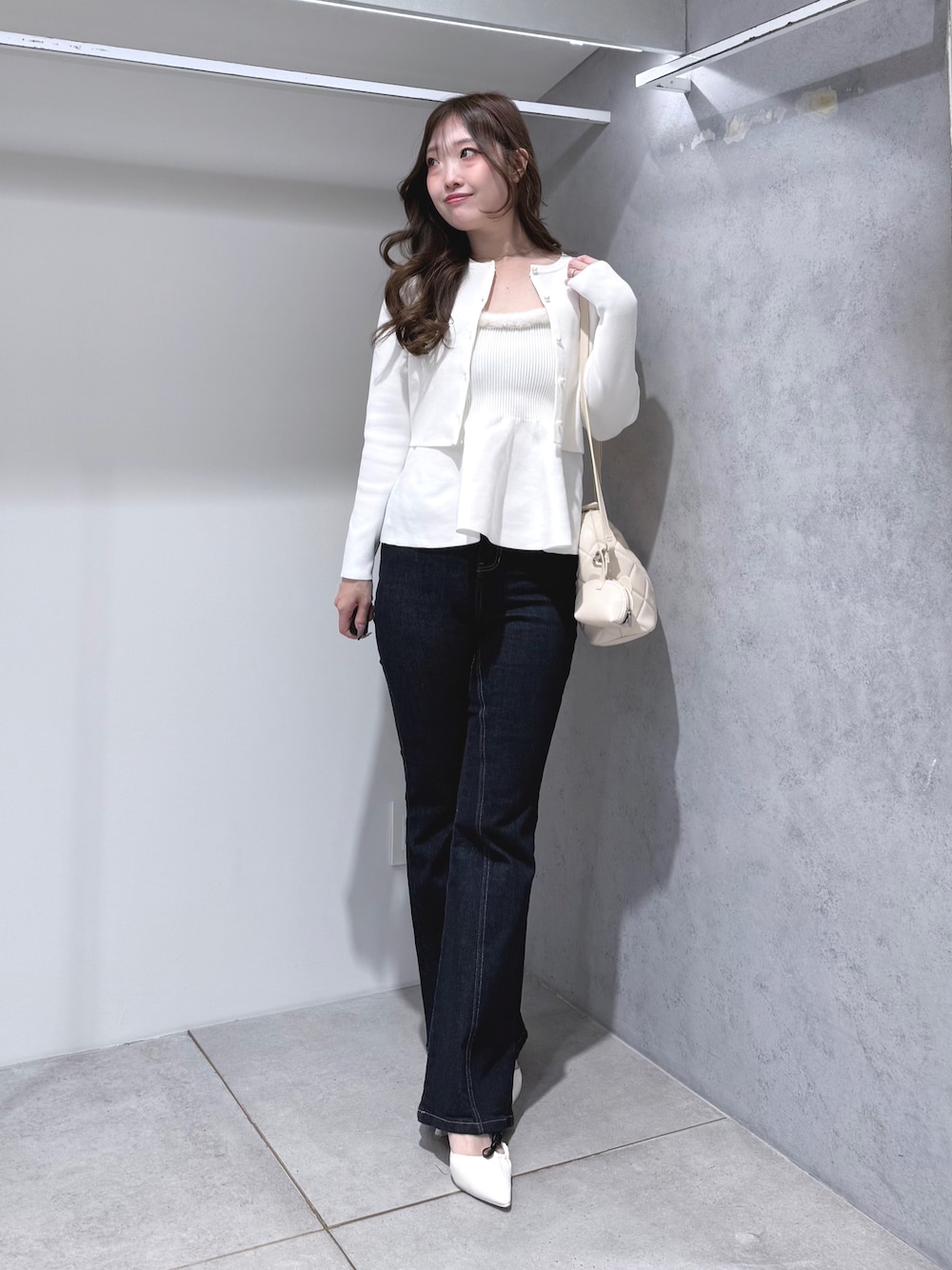 ホワイト系のニット/セーター、ブルー系のその他パンツ、ホワイト系のハンドバッグを着用したレディースの秋コーディネートの1枚目の写真
