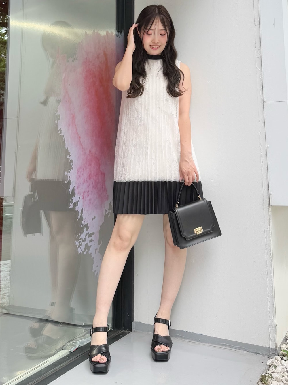ホワイト系のワンピース、ブラック系のハンドバッグ、ブラック系のサンダルを着用したレディースの夏コーディネートの1枚目の写真