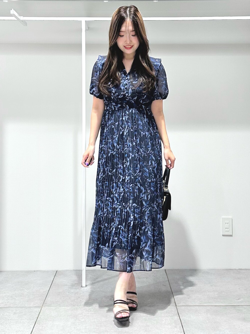 ブルー系のワンピース、ブラック系のショルダーバッグ、ブラック系のサンダルを着用したレディースの夏コーディネートの1枚目の写真
