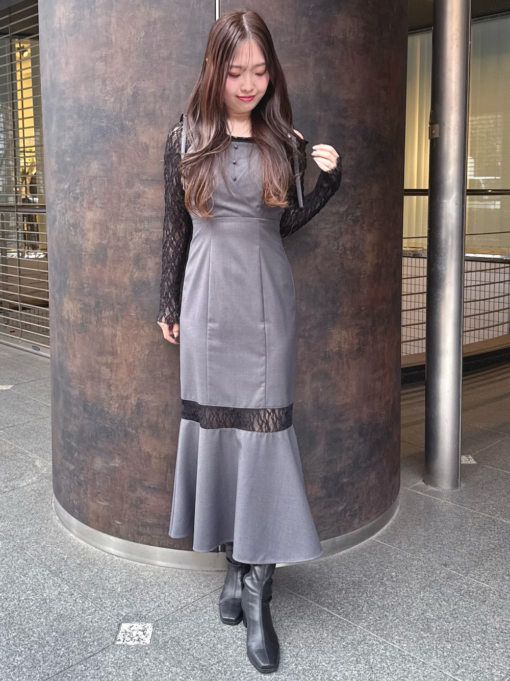 グレー系のワンピース、ブラック系のブーツを着用したレディースの秋コーディネートの1枚目の写真