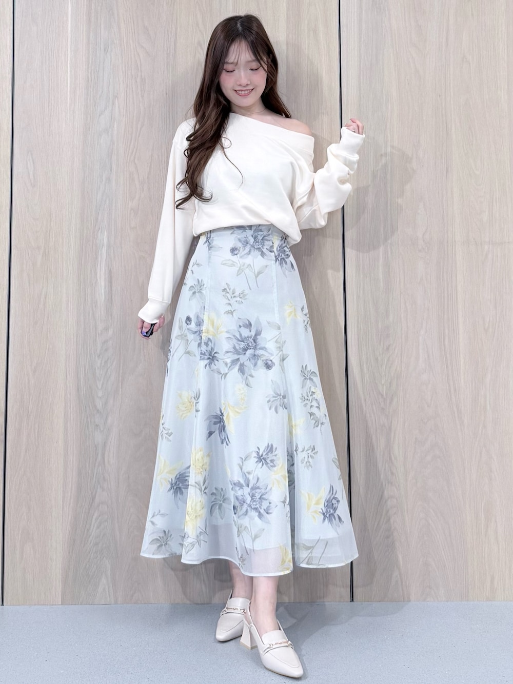 ホワイト系のTシャツ/カットソー、グリーン系のスカート、ホワイト系のパンプスを着用したレディースの春コーディネートの1枚目の写真