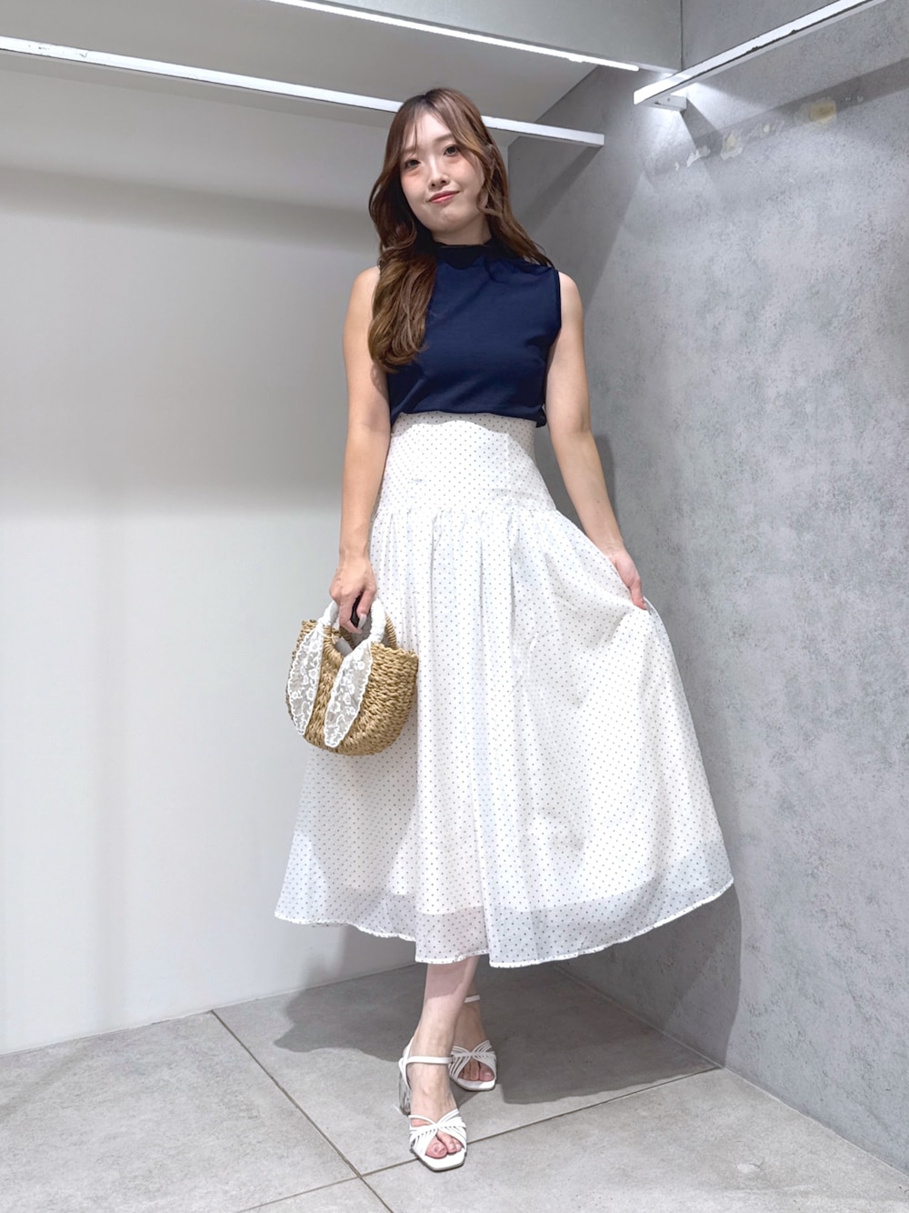ホワイト系のワンピース、ベージュ系のハンドバッグ、ホワイト系のサンダルを着用したレディースの夏コーディネートの1枚目の写真