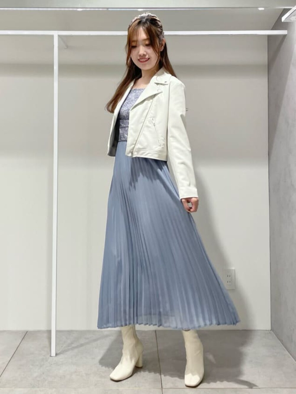 ホワイト系のブーツ、ホワイト系のライダースジャケット、ブルー系のワンピースを着用したレディースの秋コーディネートの1枚目の写真
