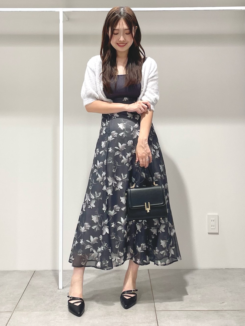 ブラック系のパンプス、ブラック系のショルダーバッグ、グレー系のワンピースを着用したレディースの夏コーディネートの1枚目の写真