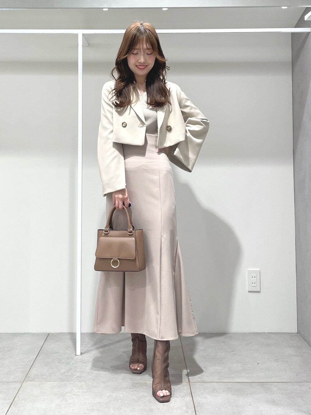 ベージュ系のニット/セーター、ベージュ系のテーラードジャケット、ベージュ系のスカートを着用したレディースの春コーディネートの1枚目の写真