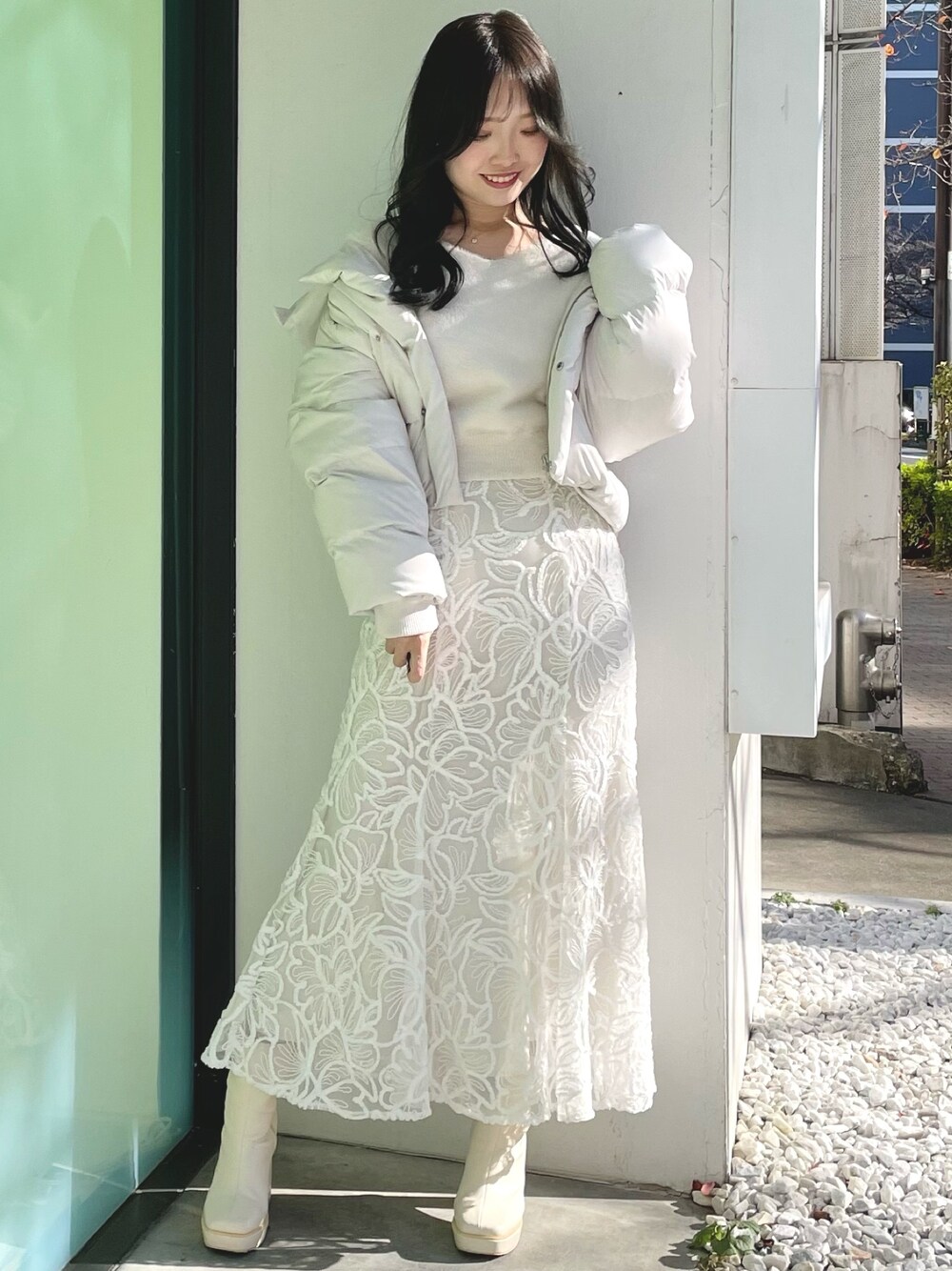 ホワイト系のダウンジャケット/コート、ホワイト系のニット/セーター、ホワイト系のスカートを着用したレディースの冬コーディネートの1枚目の写真
