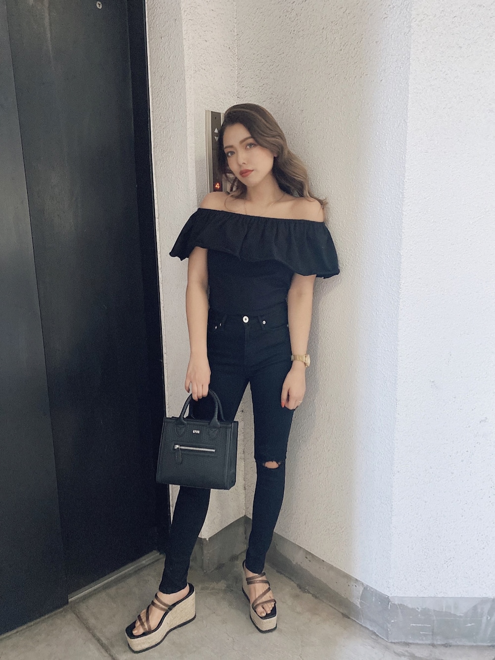 ブラック系のチノパンツ、ブラック系のサンダル、ブラック系のTシャツ/カットソーを着用したレディースの春コーディネートの1枚目の写真