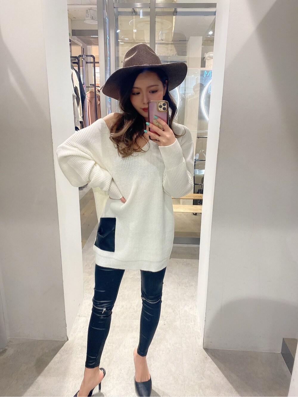 ブラック系のパンプス、ホワイト系のニット/セーター、ブラック系のレギンス/スパッツを着用したレディースの冬コーディネートの1枚目の写真