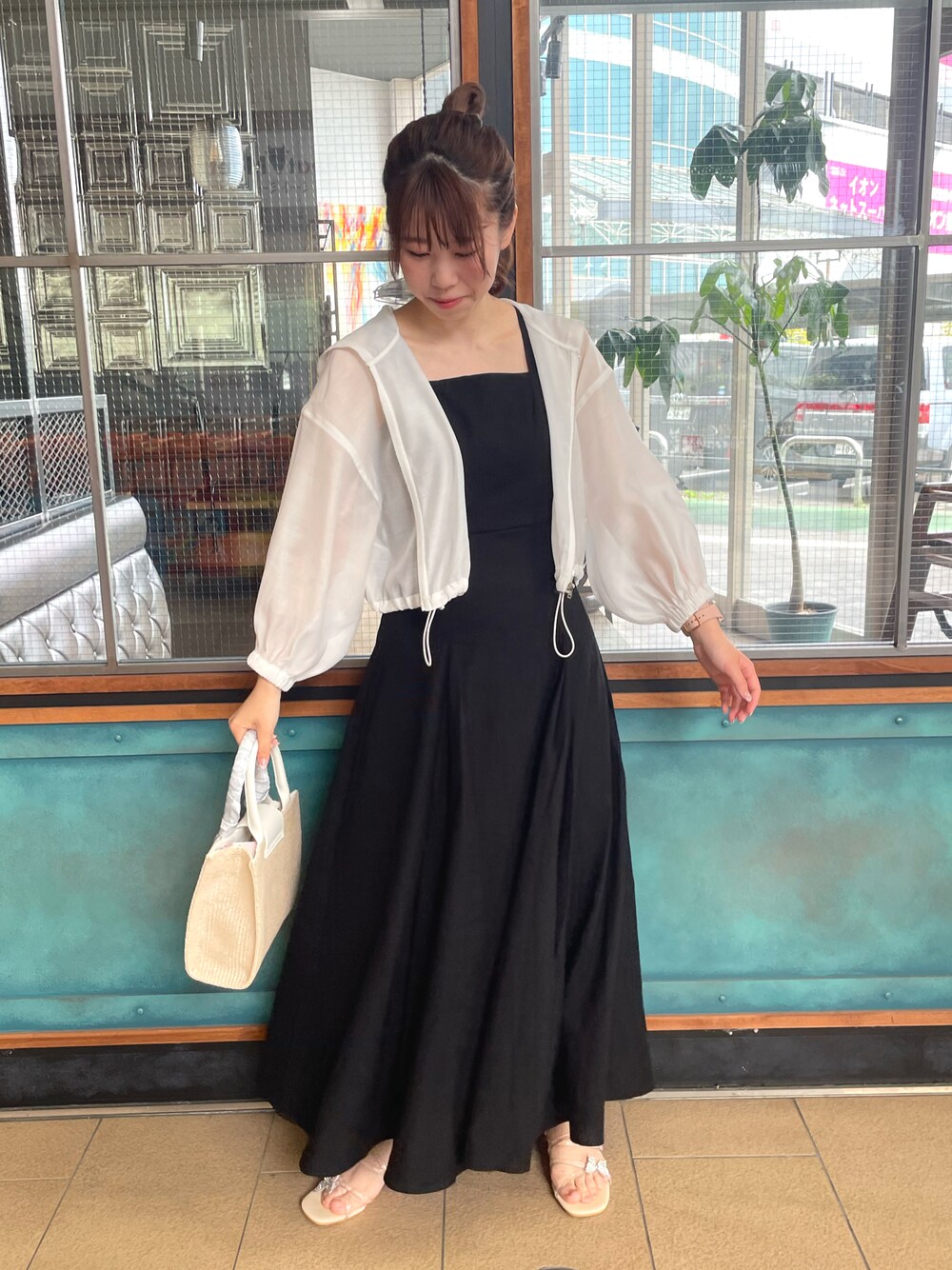 ホワイト系のマウンテンパーカー、ブラック系のワンピース、ホワイト系のショルダーバッグを着用したレディースの春コーディネートの1枚目の写真