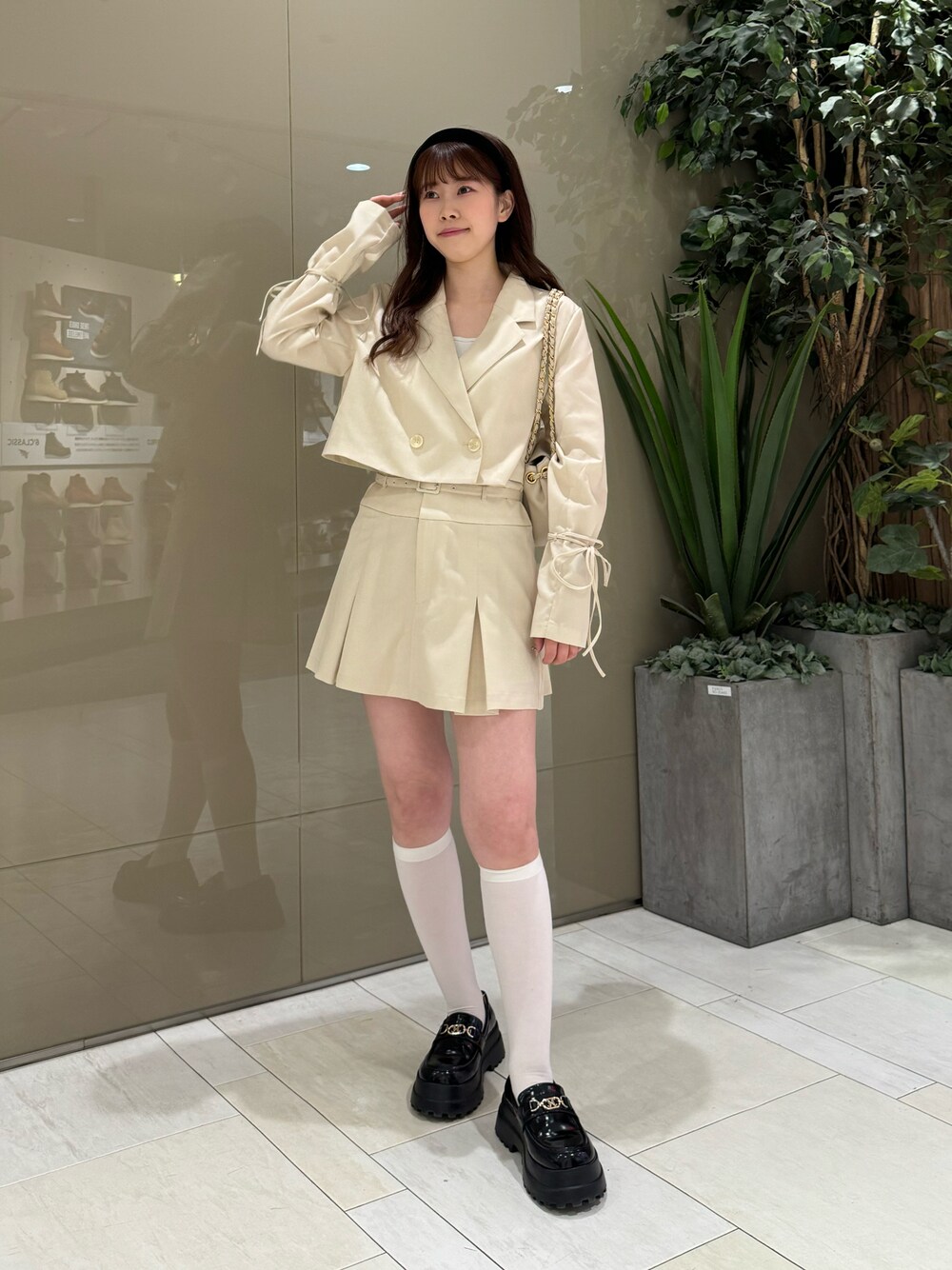 ホワイト系のテーラードジャケット、ホワイト系のスカート、ベージュ系のショルダーバッグを着用したレディースの春コーディネートの1枚目の写真